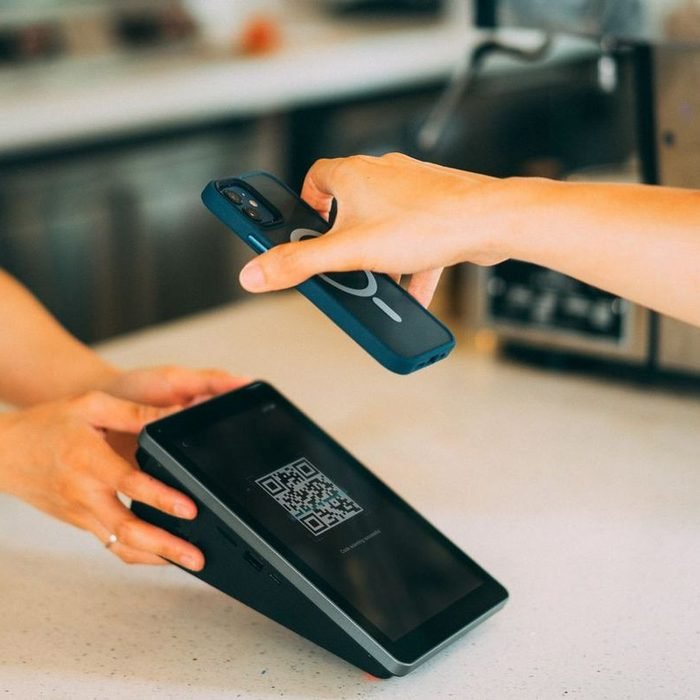 Customer paying with a phone at a QR terminal